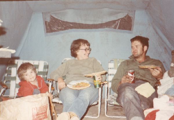 Older sister, mom, and dad camping.